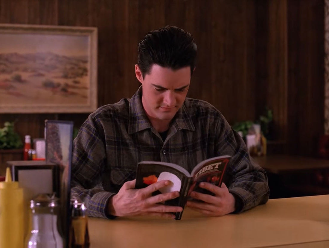Agent Cooper from Twin Peaks reading a book in the diner