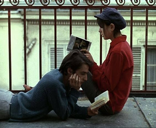 A couple reading on a balcony, the still is taken from a Godard film