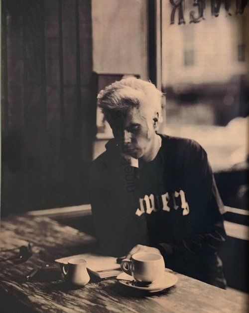 Jim Jarmusch reading a book and drinking a coffee