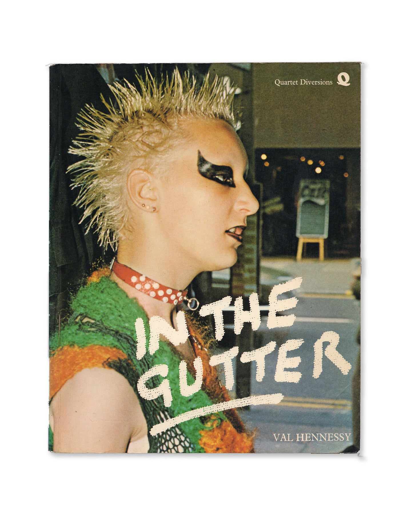 Book cover with a photo of a Punk with spiky hair and bold makeup, featuring the title 'In the Gutter' by Val Hennessy.