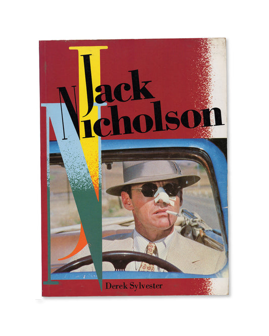 A cover of the book titled 'Jack Nicholson' by Derek Sylvester featuring a photograph of Jack Nicholson with a red and blue design.