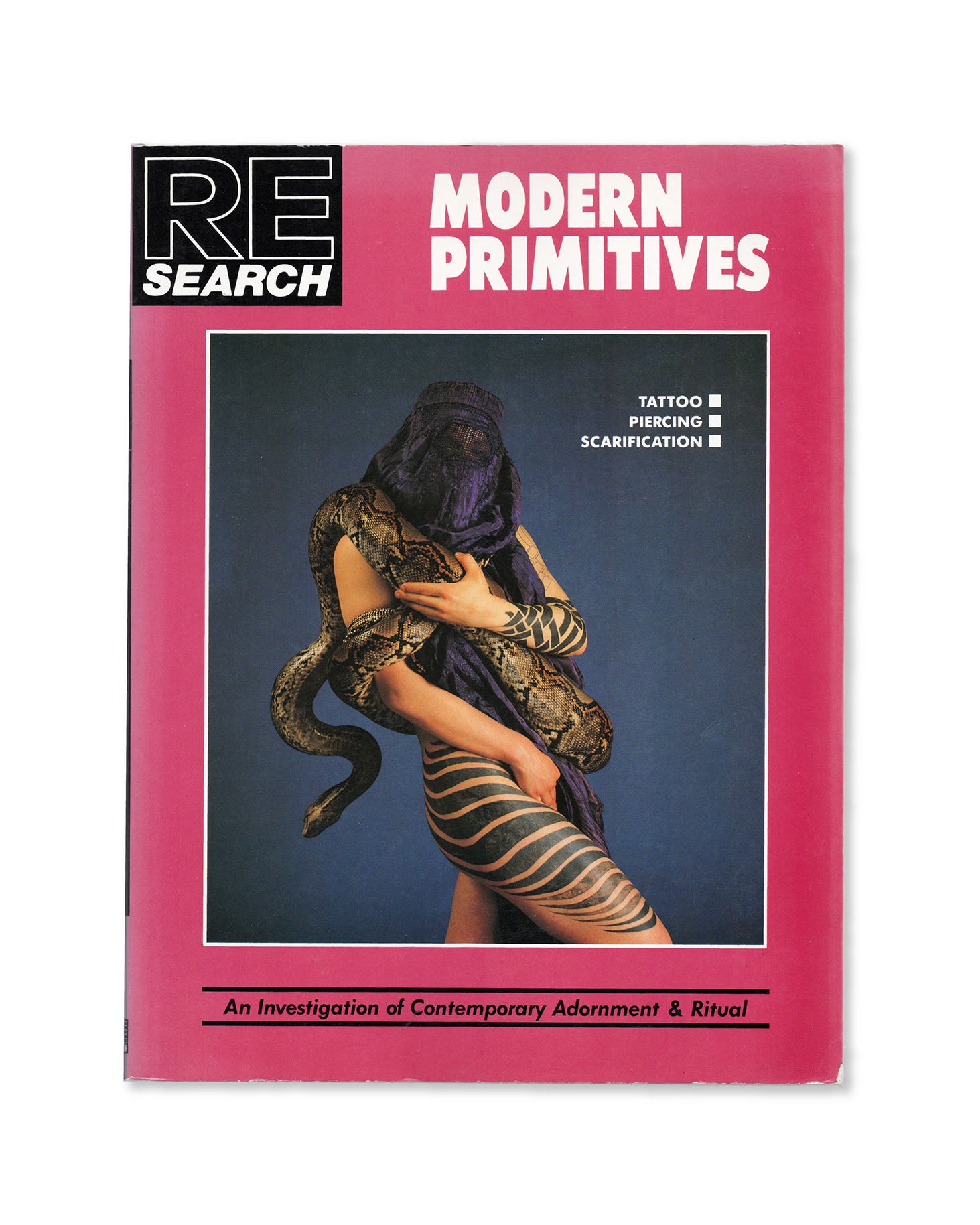 Book cover of RE/Search 'Modern Primitives' by Vivian Vale and Andrea Juno with a pink border and a central photo of a person with tattoos and a snake.