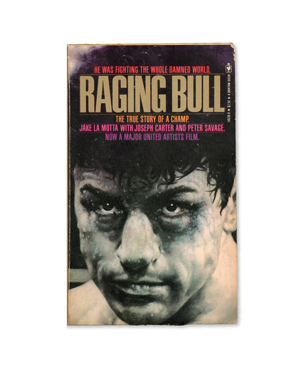 A paperback book copy of 'Raging Bull' by Jake La Motta with a black and white illustration of Robert De Niro from the film, on the front cover.